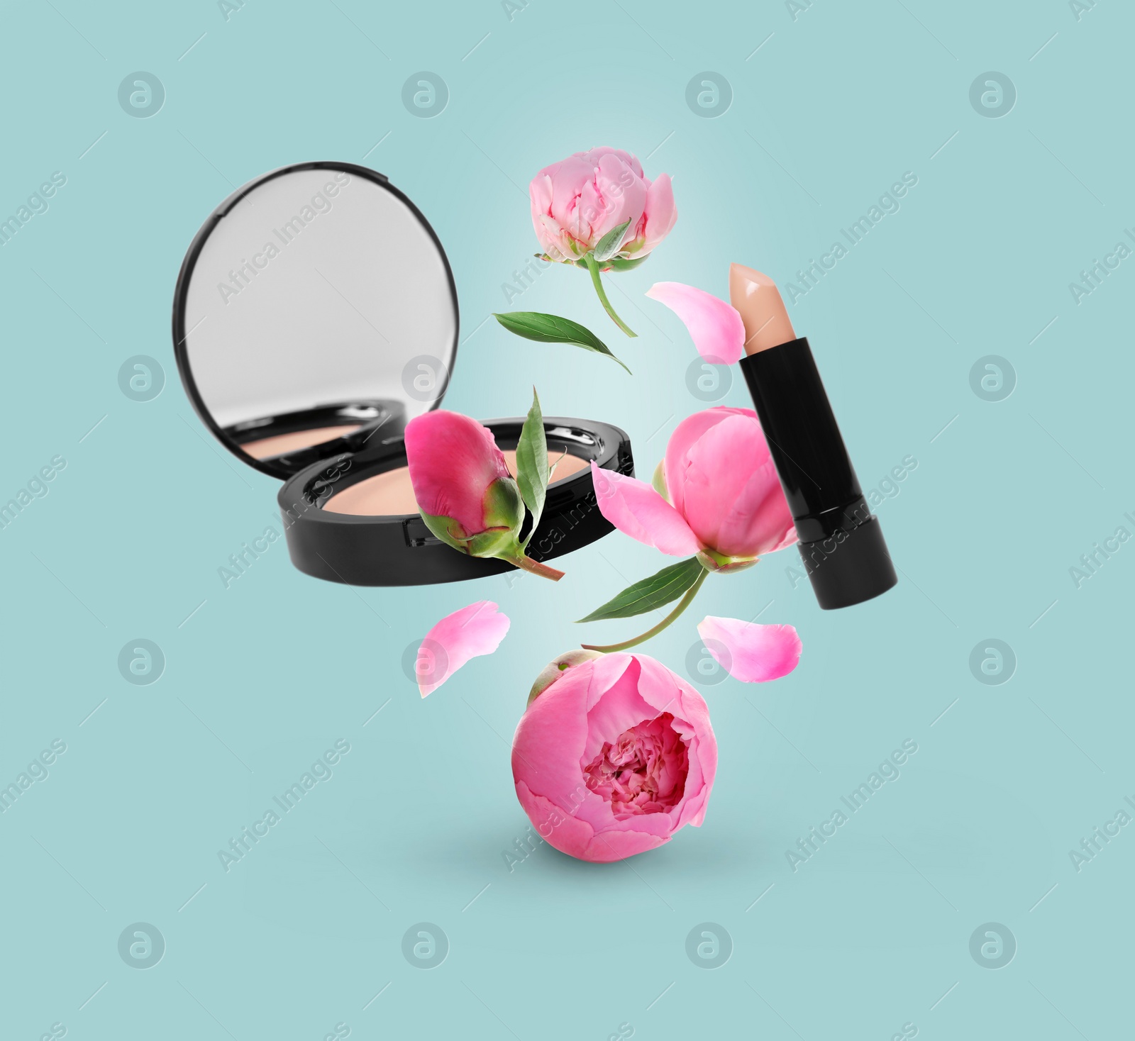 Image of Spring flowers and makeup products in air on light blue background