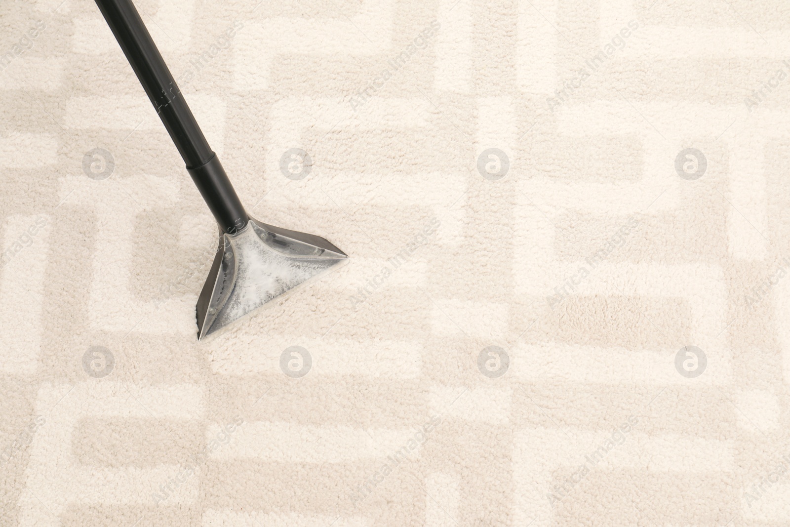 Photo of Removing dirt from carpet with vacuum cleaner indoors, closeup. Space for text