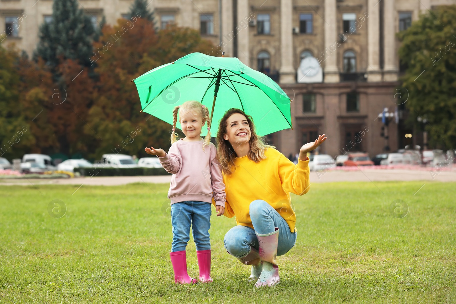 Photo of Happy mother and daughter with umbrella in park