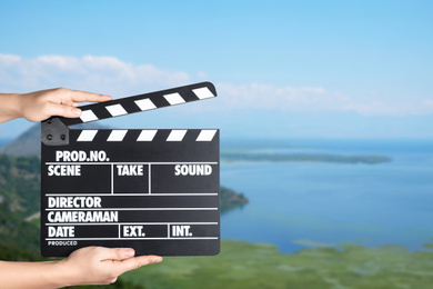 Image of Assistant holding clapperboard outdoors, closeup. Cinema production 