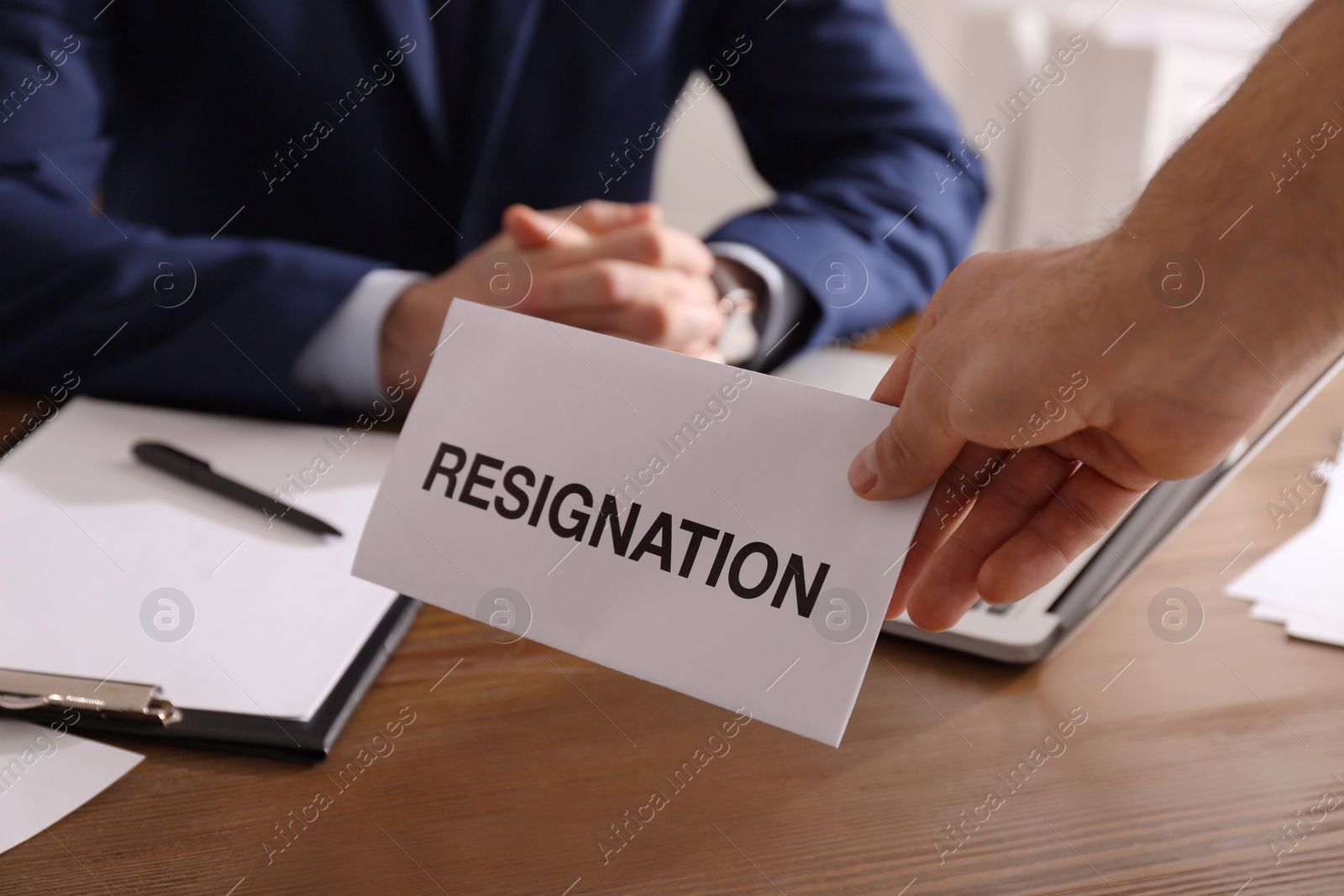 Photo of Employee giving resignation letter to boss in office, closeup