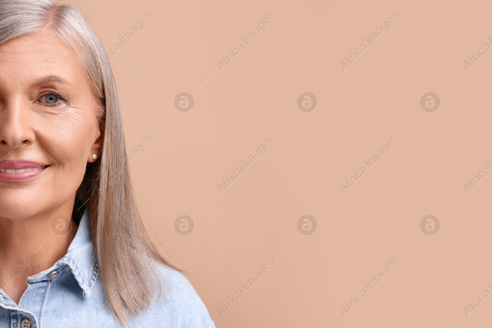 Photo of Portrait of beautiful middle aged woman on beige background, closeup. Space for text