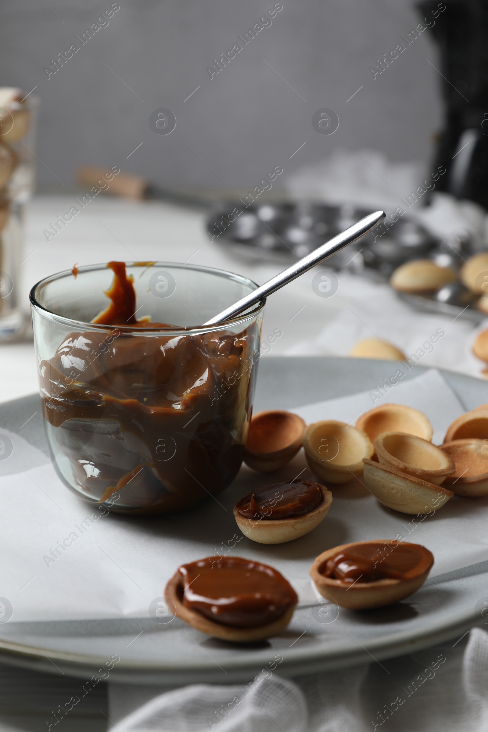 Photo of Delicious walnut shaped cookies with condensed milk on plate, closeup