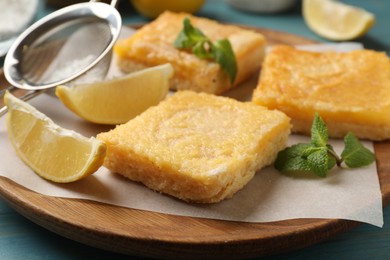 Tasty lemon bars and mint on table, closeup