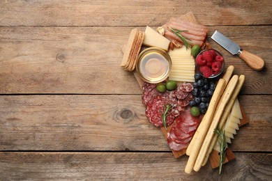 Photo of Snack set with delicious Parmesan cheese on wooden table, top view. Space for text