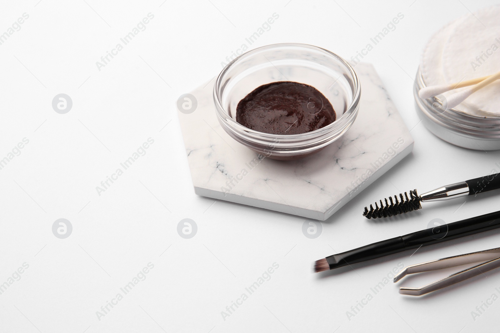 Photo of Eyebrow henna and professional tools on white background, space for text