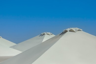 Photo of Beach umbrellas against blue sky on sunny day, closeup