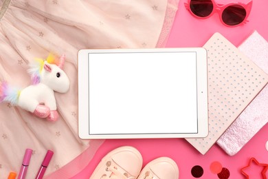 Photo of Modern tablet, skirt, toy unicorn and stationery on pink background, flat lay. Space for text