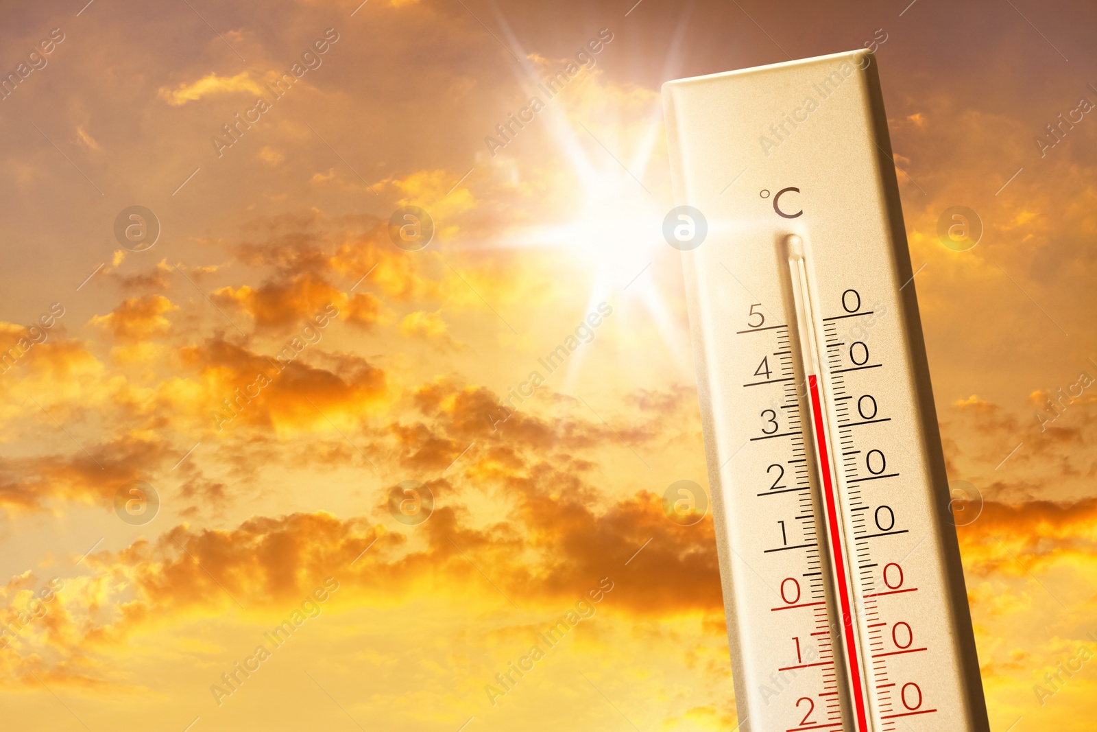 Image of Weather thermometer showing high temperature and sunny sky with clouds on background