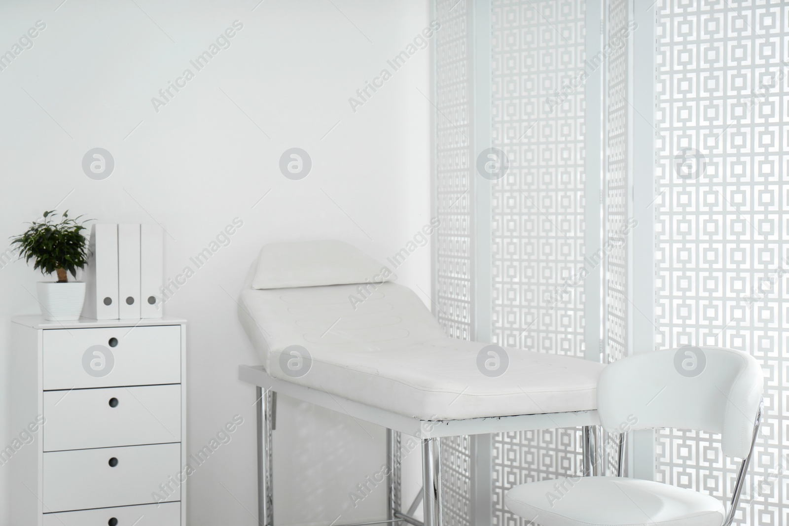 Photo of Examination room with modern couch and folding screen in clinic