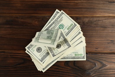 Photo of Money exchange. Dollar banknotes on wooden background, top view