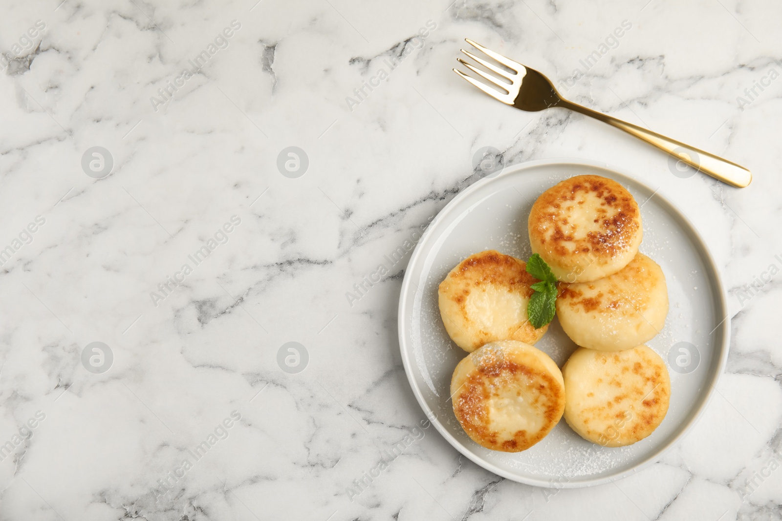 Photo of Delicious cottage cheese pancakes with mint and icing sugar on white marble table, flat lay. Space for text