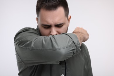 Photo of Sick man coughing on white background, closeup. Cold symptoms
