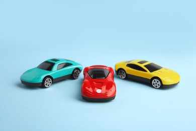 Different bright cars on light blue background. Children`s toys