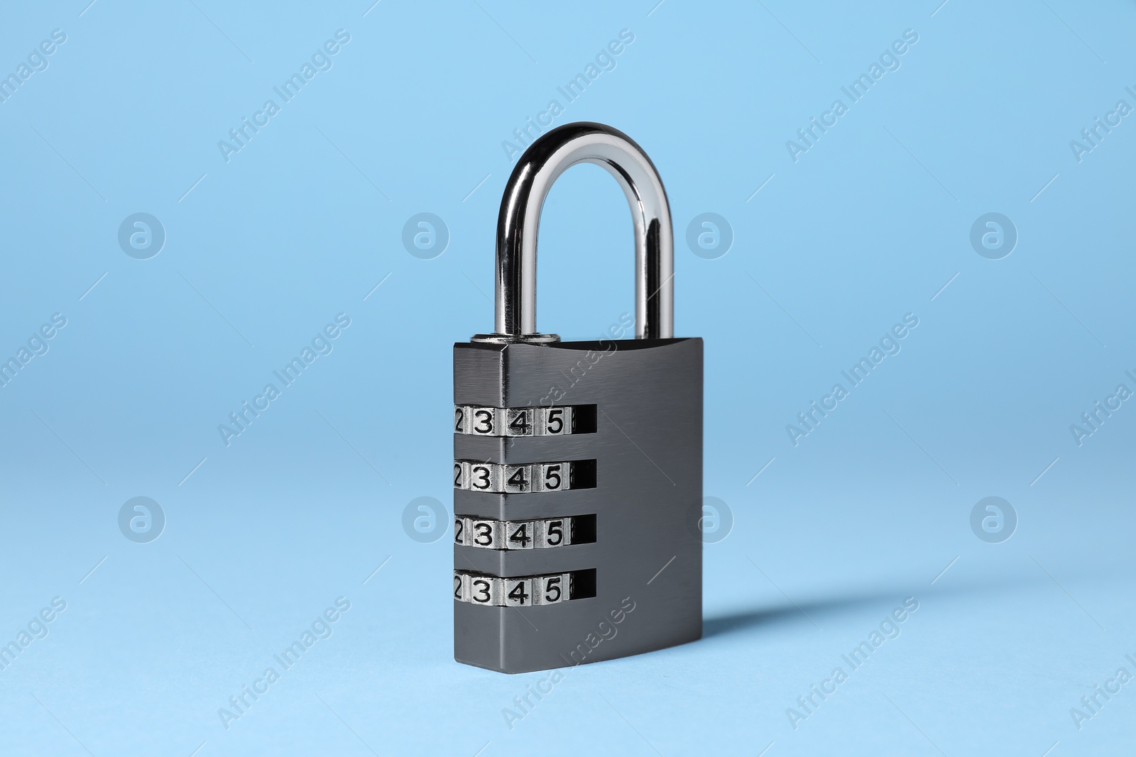 Photo of Steel combination padlock on light blue background