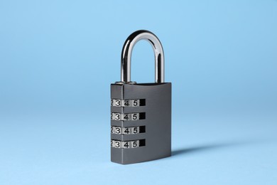 Photo of Steel combination padlock on light blue background