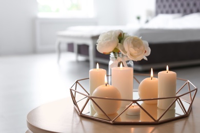 Photo of Burning candles on table indoors. Interior decor element