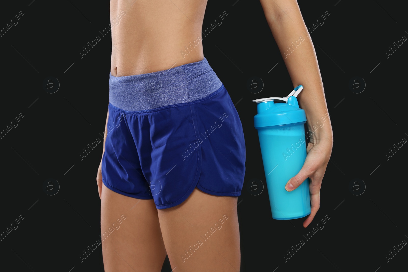 Photo of Woman with bottle of protein shake on black background