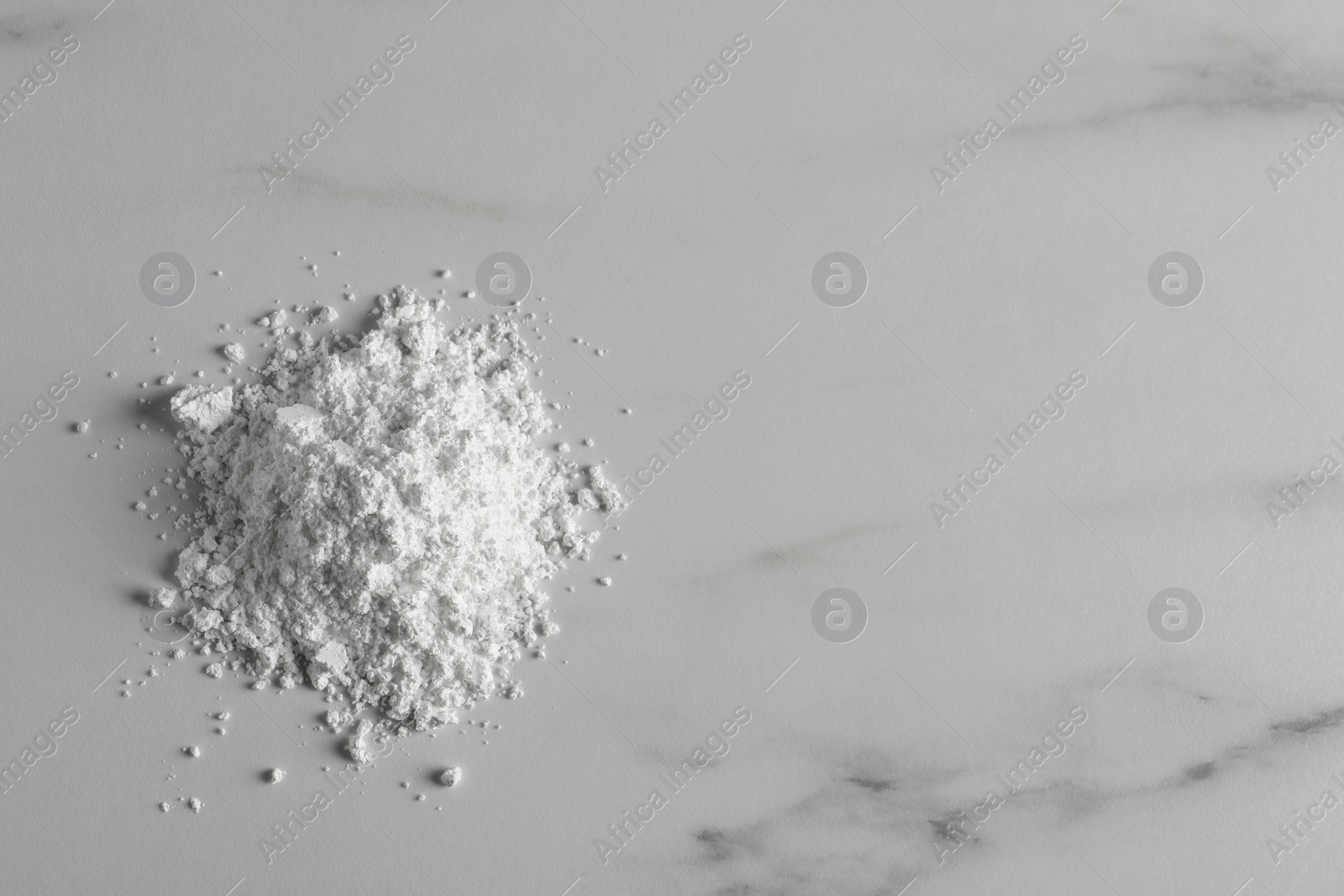 Photo of Heap of calcium carbonate powder on white marble table, top view. Space for text