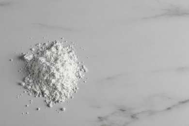 Photo of Heap of calcium carbonate powder on white marble table, top view. Space for text