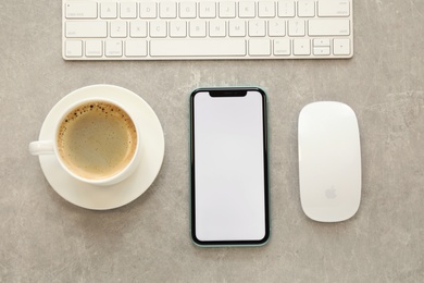 MYKOLAIV, UKRAINE - JULY 8, 2020: Iphone 11 Pro Max with blank screen, cup of coffee and keyboard on light table, flat lay. Space for design