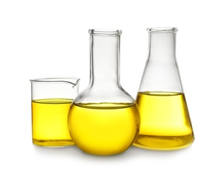 Laboratory glassware with yellow liquid on white background