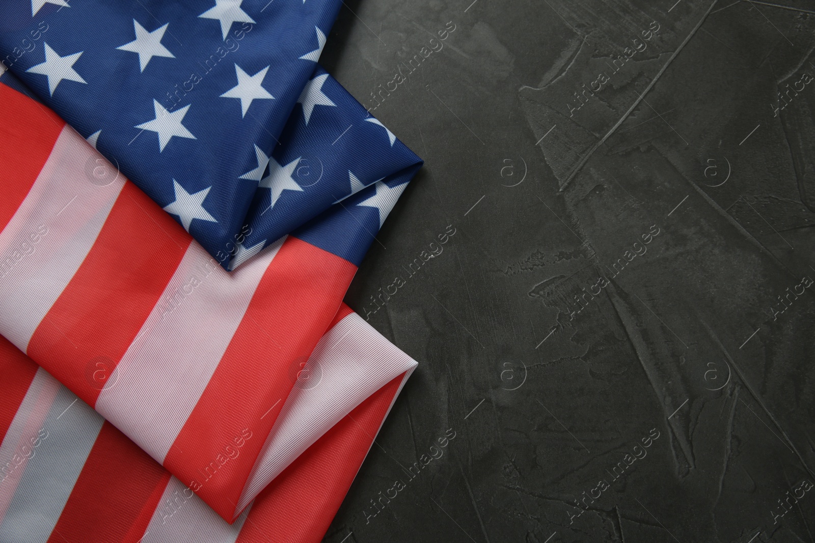 Photo of Flag of USA on black table, top view. Space for text