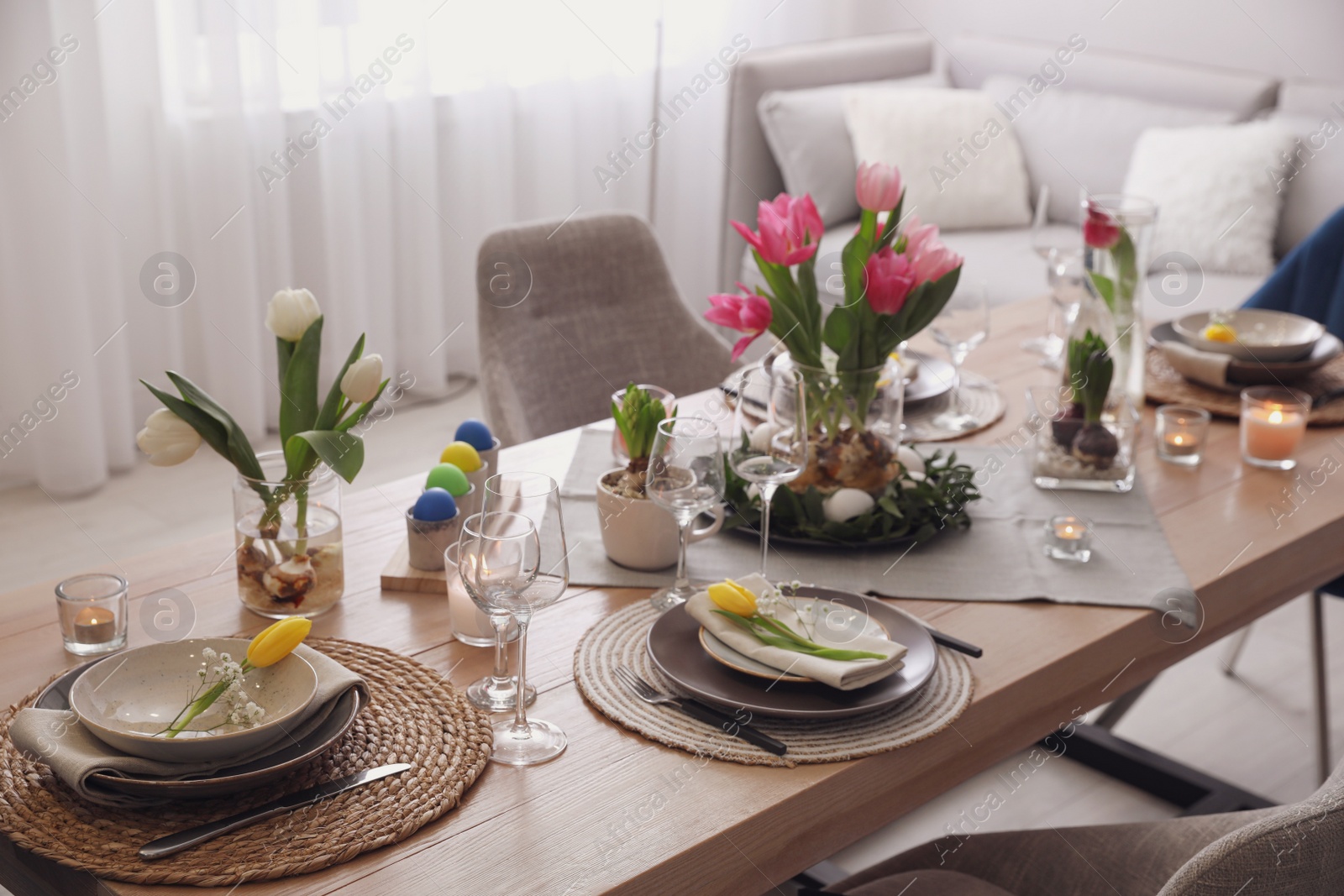 Photo of Beautiful Easter table setting with beautiful flowers in living room