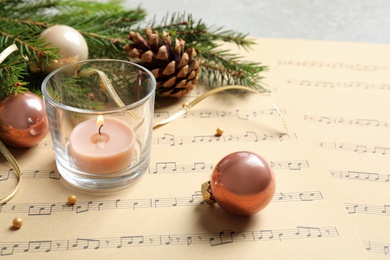 Composition with Christmas decorations and music sheets on table