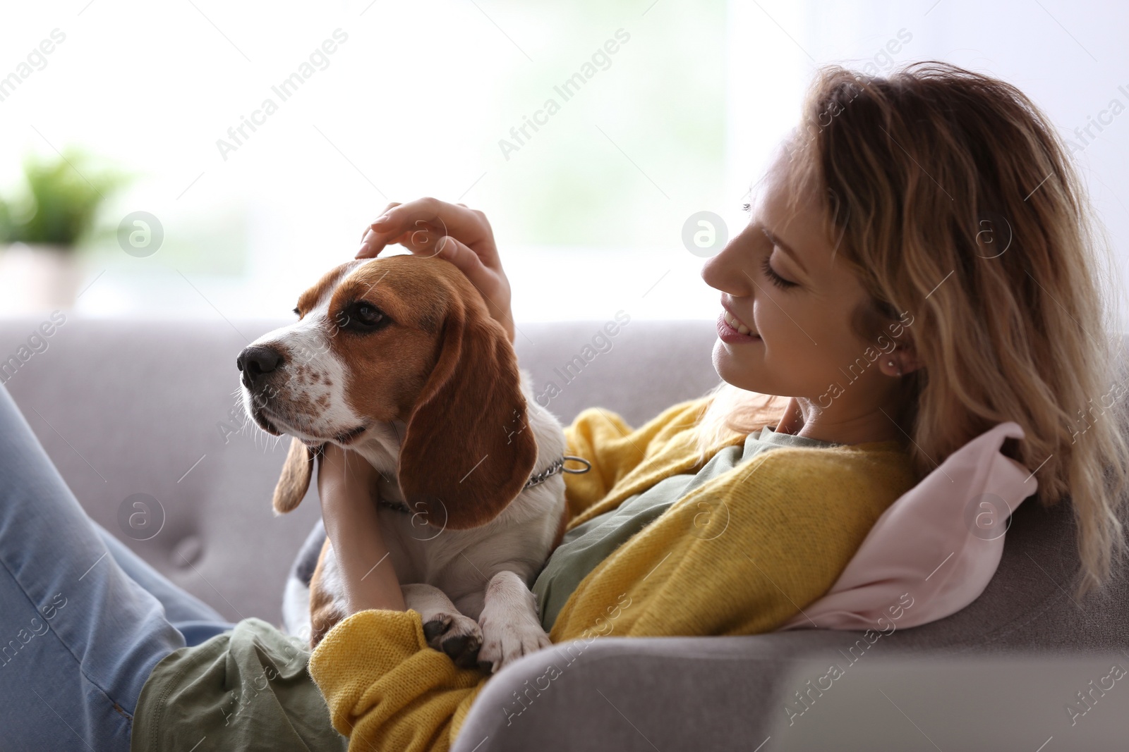 Photo of Young woman with her dog at home
