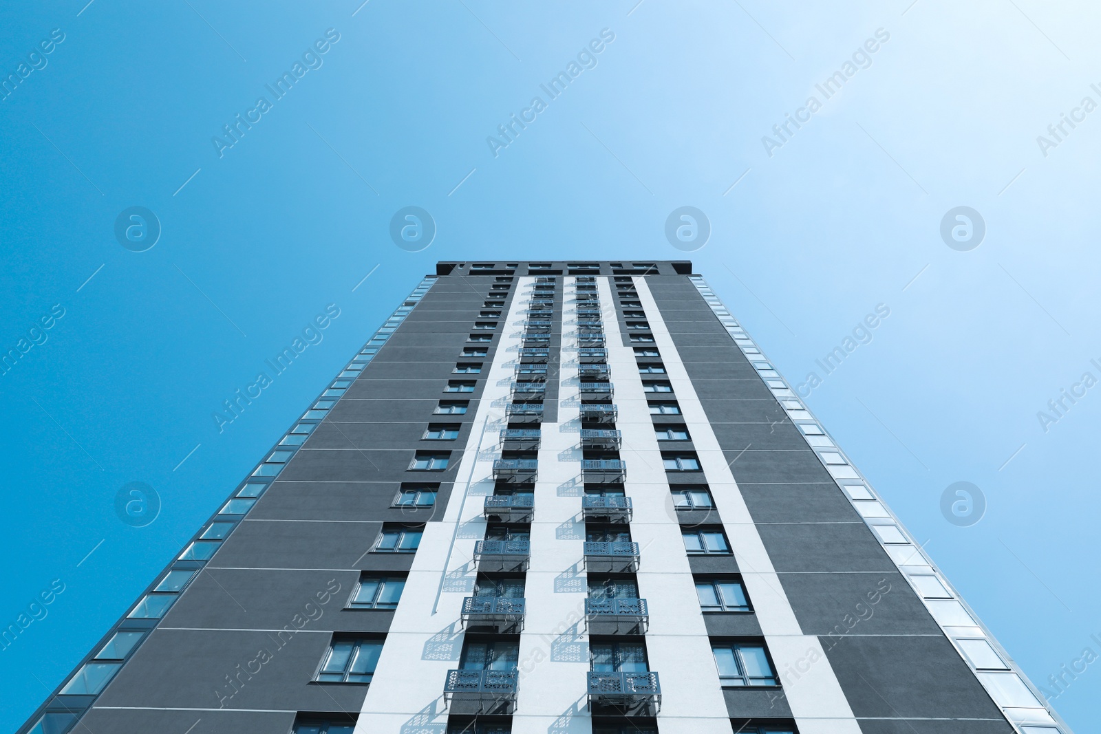 Photo of Low angle view of modern building against blue sky