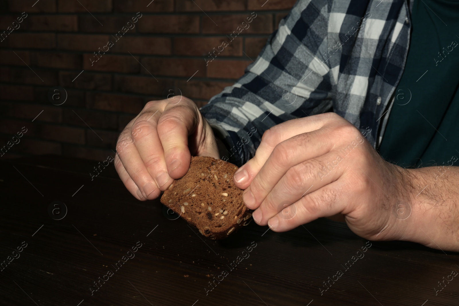 Photo of Poor senior man with bread at table, closeup