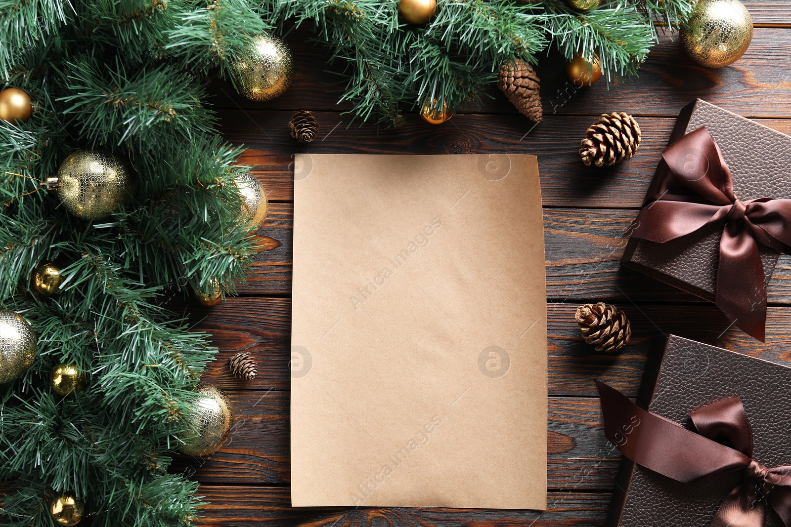 Photo of Blank paper sheet, gift boxes and Christmas garland on wooden table, flat lay with space for text. Letter to Santa