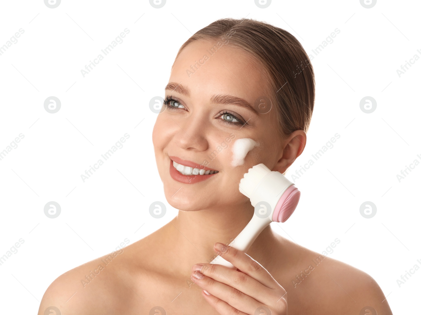 Photo of Young woman washing face with brush and cleansing foam on white background. Cosmetic products