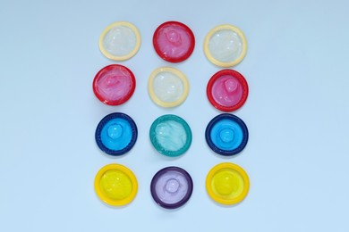 Photo of Condoms on light blue background, flat lay. Safe sex