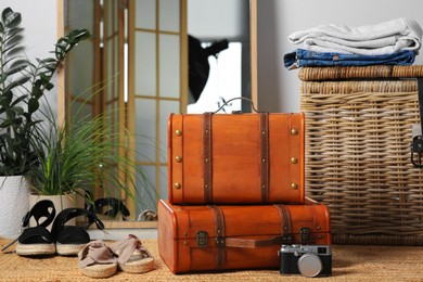 Photo of Stylish brown suitcases and shoes on carpet indoors