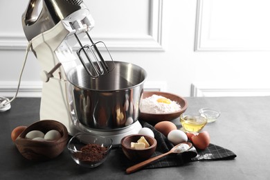 Stand mixer and different ingredients for dough on grey table