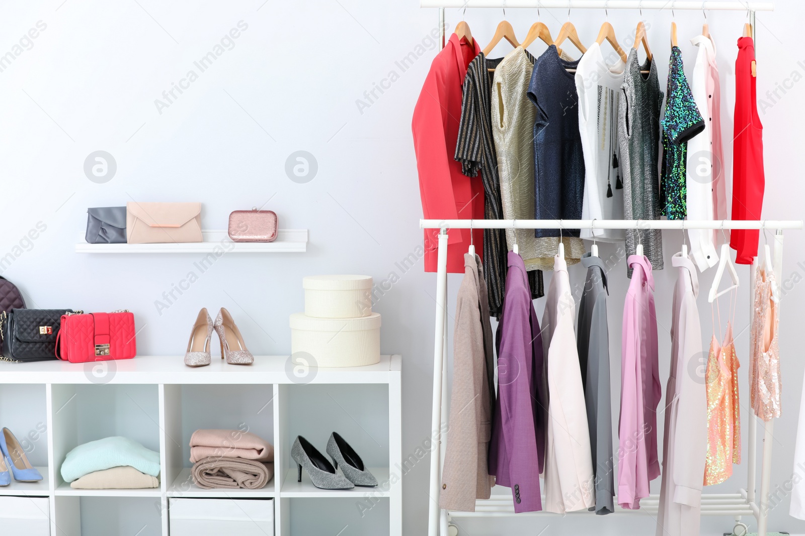 Photo of Racks with stylish clothes in light room