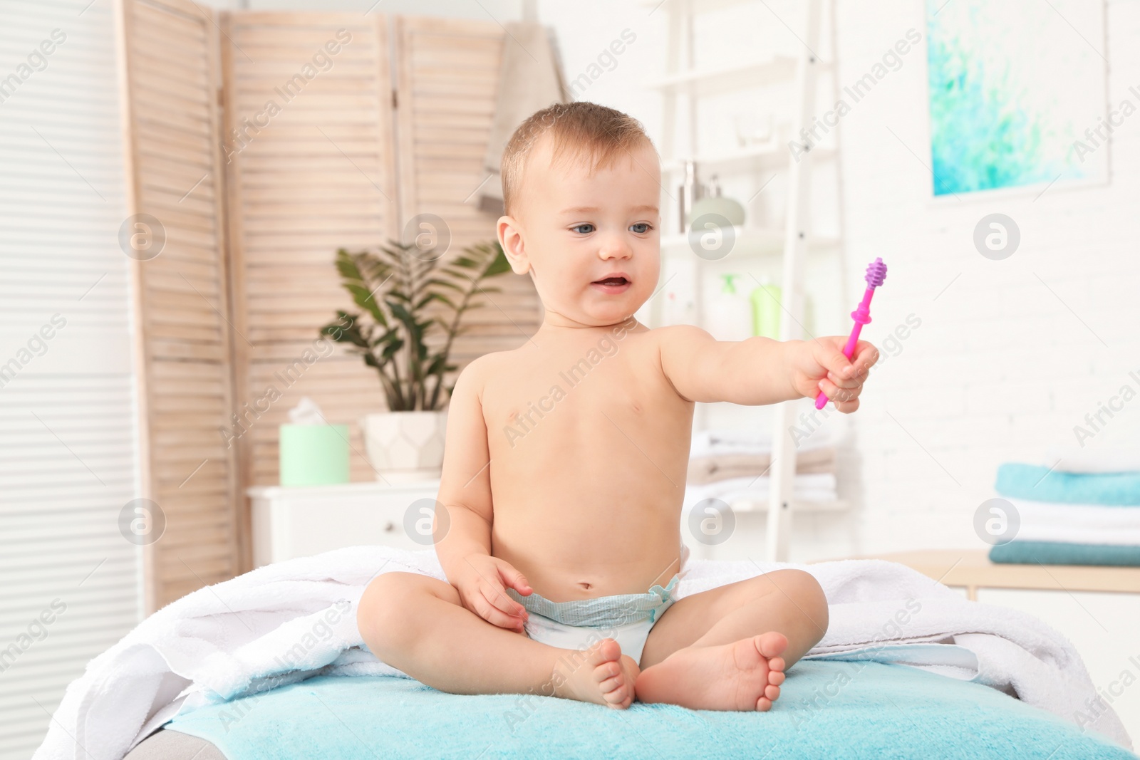 Photo of Cute little boy with toothbrush on blurred background