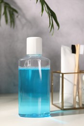 Photo of Bottle of mouthwash on white table in bathroom