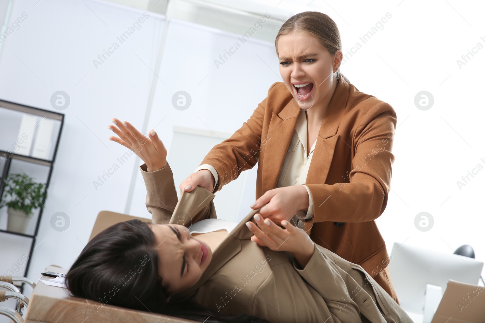 Photo of Emotional colleagues fighting in office. Workplace conflict