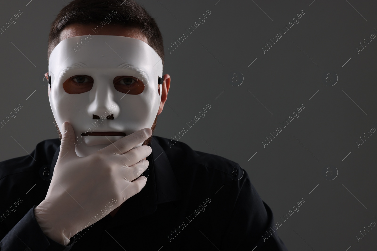 Photo of Man in mask and gloves on grey background. Space for text