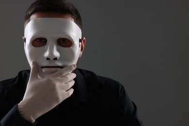 Photo of Man in mask and gloves on grey background. Space for text