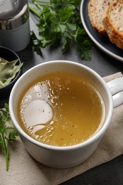 Hot delicious bouillon in cup on grey table, above view