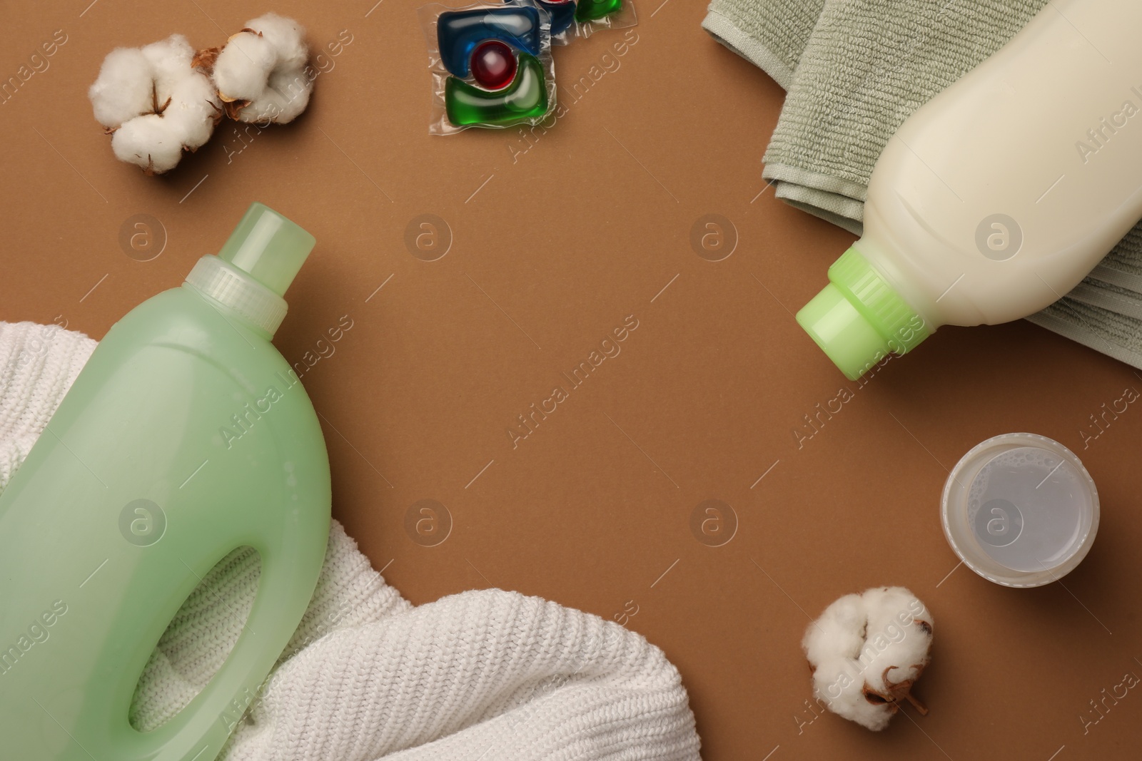 Flat lay composition with bottle of fabric softener and laundry detergent pods on brown background, space for text Photo of Flat lay composition with bottle of fabric softener and laundry detergent pods on brown background, space for text