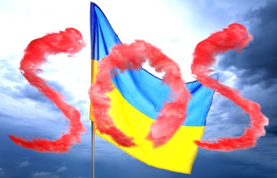 Image of Word SOS made of red smoke and national flag of Ukraine against cloudy sky