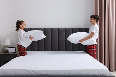 Photo of Brother and sister changing bed linens together in bedroom