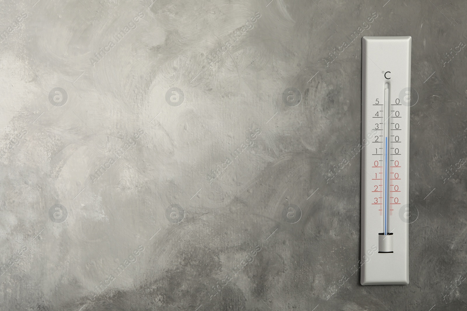 Photo of Weather thermometer on grey wall. Space for text