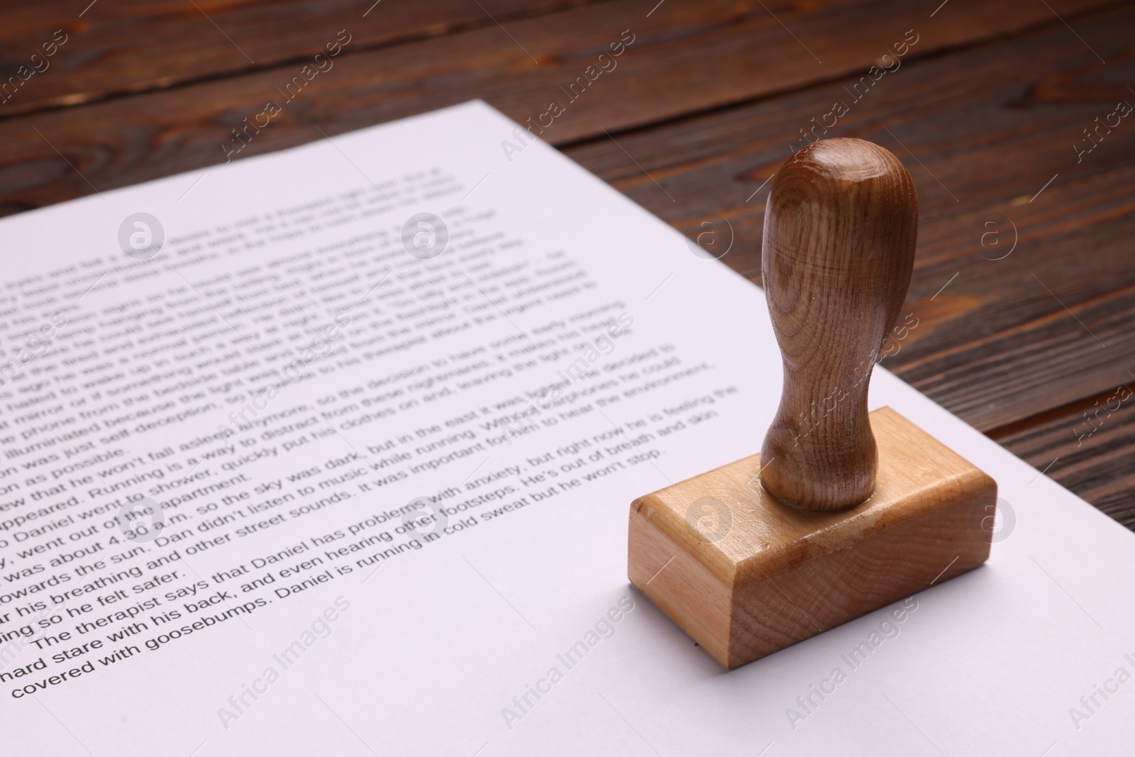 Photo of One stamp tool and document on wooden table, closeup