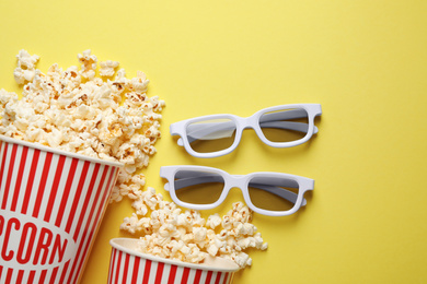 Photo of Flat lay composition with delicious popcorn on yellow background